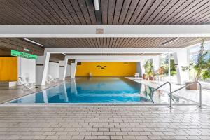 a swimming pool in a building with a yellow wall at Ferienwohnung Harmonie mit Pool und Fitness in Sankt Englmar