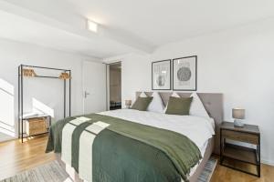 a white bedroom with a large bed and a staircase at Klara 1022 - Olma, Spital, Uni St- Gallen in St. Gallen