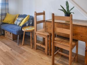 un salon avec un canapé, une table et des chaises dans l'établissement Dalton Cottage, à Penzance