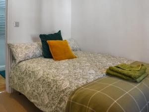 un lit avec deux oreillers dessus dans l'établissement Dalton Cottage, à Penzance