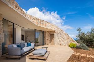 a patio of a house with two couches and a table at Villa Nai 3.3 in Žman