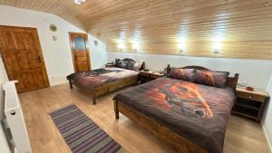 a bedroom with two beds with a horse painted on them at Casa Taraneasca "OM BUN" in Alămor
