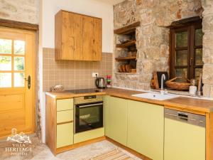 une cuisine avec des appareils électroménagers jaunes et un mur en pierre dans l'établissement Pocitelj Heritage Stone Villa, à Počitelj 21 autres photos