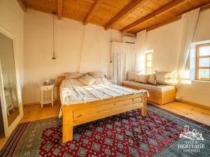 - une chambre avec un lit dans une pièce dotée d'un tapis dans l'établissement Pocitelj Heritage Stone Villa, à Počitelj