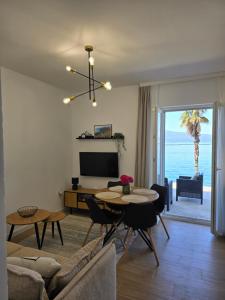 a living room with a table and a living room with the ocean at Apartmani Nikolić "Na pjeni od mora" in Tivat +45 photos