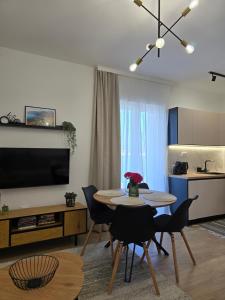 a living room with a table and chairs and a kitchen at Apartmani Nikolić "Na pjeni od mora" in Tivat