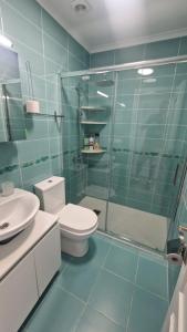 a bathroom with a toilet and a glass shower at Casa Paseo in Torrevieja +17 photos