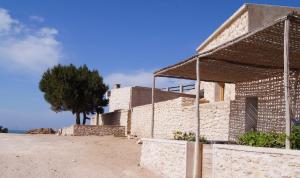 a brick house with a tree in the background at The Little Beach Cottage in Sidi Kaouki