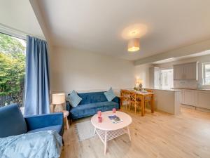 a living room with a blue couch and a table at Seashell Haven in Beadnell