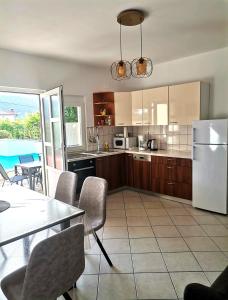 a kitchen with a table and a white refrigerator at Apartments Gvacic in Rab