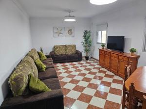 a living room with a couch and a television at La Casita in Chiclana de la Frontera