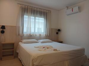 ウニアン・ダ・ビトリアにあるHotel Turellaのベッドルーム1室(ベッド1台、バスローブ付)