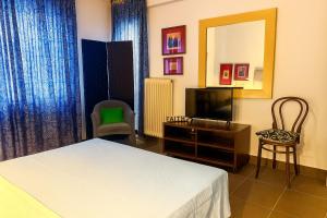 a hotel room with a bed and a television at Verdant Escape Corfu in Corfu