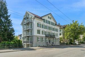 a large white building on the side of a street at Klara 1022 - Olma, Spital, Uni St- Gallen in St. Gallen