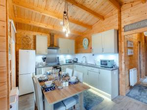 a kitchen with a table and chairs in a cabin at Seashell Lodge in Gairloch