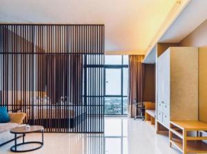 a living room with a bed and a table in it at Melaka Pines 99 Suite Hotel in Melaka