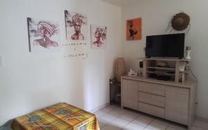 a living room with a tv on a dresser at Ti case Mellauman : Anse Plage in Les Trois-Îlets