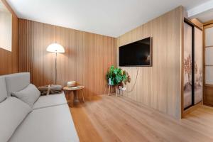 a living room with a couch and a tv on a wall at Japanese-Inspired Hideaway in Stavanger Calm, Cozy, and One of a Kind in Stavanger