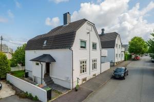 a white house with a black roof on a street at Japanese-Inspired Hideaway in Stavanger Calm, Cozy, and One of a Kind in Stavanger