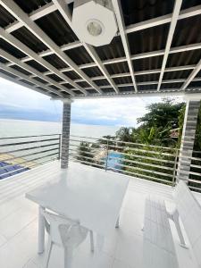 a white dining room with a view of the ocean at Becca's Vacation House 