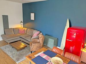 a living room with a couch and a red refrigerator at Bolingey Chapel in Perranporth