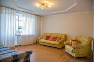 a living room with two chairs and a window at Apartment NG Na Chertygasheva in Abakan