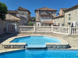 a swimming pool in a courtyard with a fence at Charmant studio avec piscine in Ruoms