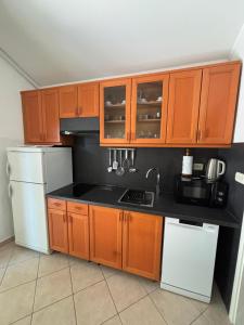 a kitchen with wooden cabinets and a white refrigerator at Apartment Ivic in Bol