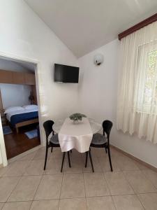 a dining room with a table and chairs and a bedroom at Apartment Ivic in Bol