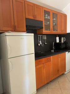 a kitchen with a white refrigerator and wooden cabinets at Apartment Ivic in Bol