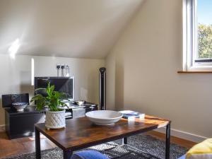 a living room with a table with a bowl on it at Garden Studio in St Austell