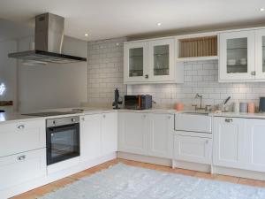 a white kitchen with white cabinets and appliances at The Parade - Uk48433 in Bridlington