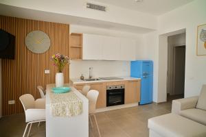 a kitchen with a table and a blue refrigerator at Dimoradipa in Santa Maria di Castellabate