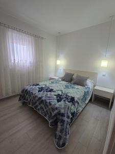 a bedroom with a bed with a blue and white blanket at Casinha do Mar in Carvide