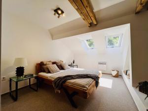 a bedroom with a bed and two windows at The Mountain Sky Apartment - prostorný loft 212 m2 s lesem za okny vhodný pro rodiny s dětmi, terasa, dětský koutek, parkování zdarma in Jeseník