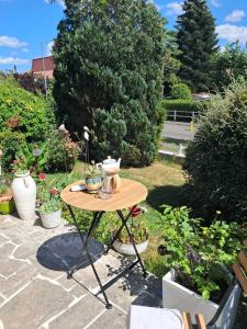a small table in a garden with plants at Chez Toinette in Bretteville-sur-Odon