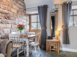 Un comedor con una mesa y sillas y una pared de ladrillos. en Jacob's Barn - Uk46733, en Wootton