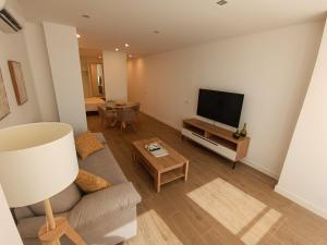 a living room with a couch and a flat screen tv at Apartamentos DALA in Madrid