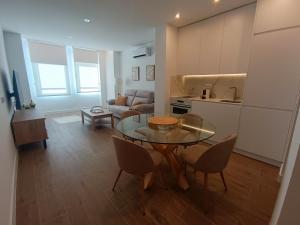 a living room with a table and chairs and a kitchen at Apartamentos DALA in Madrid