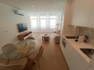 a kitchen and living room with a glass table and chairs at Apartamentos DALA in Madrid +16 photos
