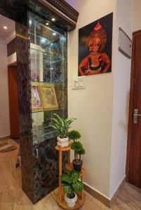 a room with potted plants and a painting on the wall at SM Stay Inn in Mangalore