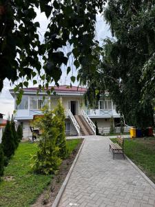 a white house with a bench in front of it at Квартира-студия Радуга Вест Прованс in Koshkolʼ