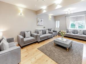 Una gran sala de estar con sofás y una mesa. en Whydown Cottage, en Hooe