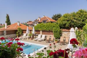 Una piscina con sillas y sombrillas al lado de una casa. en VILLA SOL, en Sunny Beach
