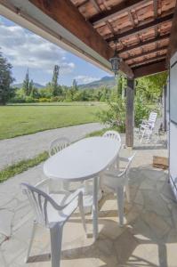 ein weißer Tisch und Stühle auf einer Terrasse in der Unterkunft Gîte Les Galinettes en Ardèche in Saint-Martin-le-Supérieur