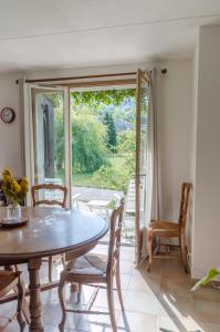 ein Esszimmer mit einem Tisch und Stühlen sowie einer Glasschiebetür in der Unterkunft Gîte Les Galinettes en Ardèche in Saint-Martin-le-Supérieur