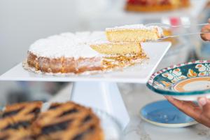a person holding a plate with a piece of cake at Pagoda Lifestyle Hotel in Ischia