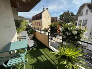 a balcony with a blue table and chairs and plants at Cocon douillet résidence calme in Pau