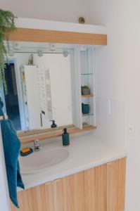 ein Waschbecken mit einem Spiegel und einem Fenster in der Unterkunft Gîte Les Galinettes en Ardèche in Saint-Martin-le-Supérieur + 2 Fotos