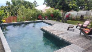 a swimming pool in a yard with a wooden deck at Ty kaz plato in Saint-Leu